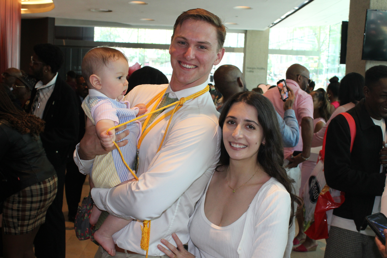 NYCPM grad with baby and wife at graduation