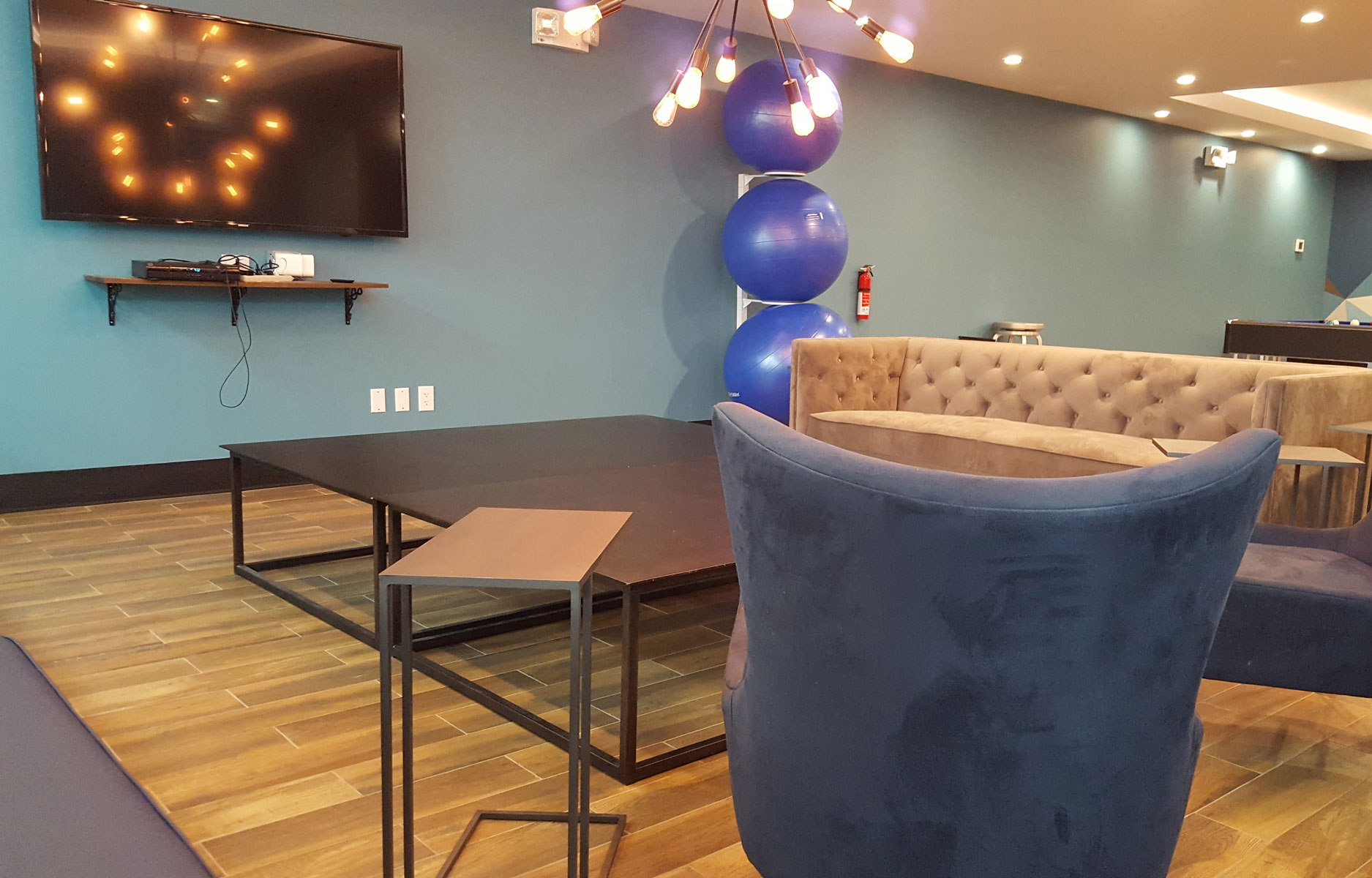 Student lounge with tv, tables, couches, and exercise balls in background