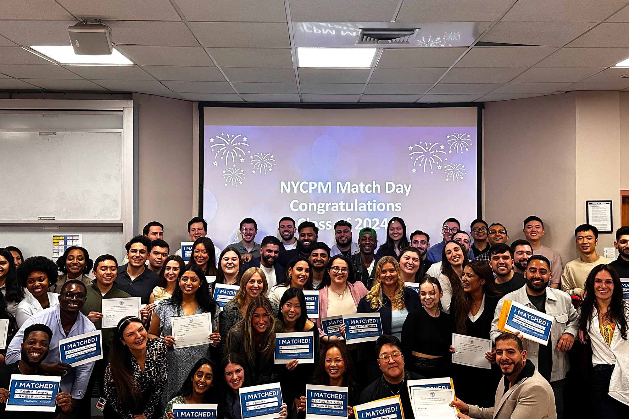 Group of students smiling while holding their match day results