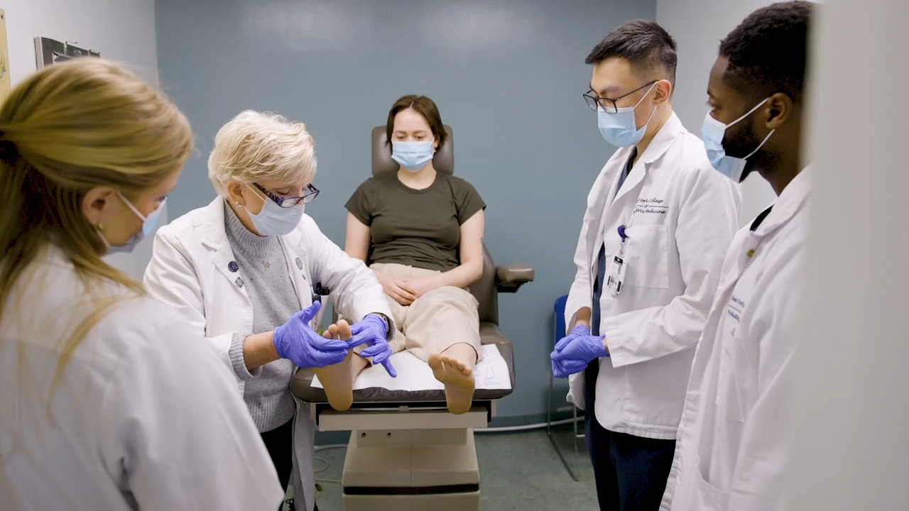 professor and students examining a patient's feet