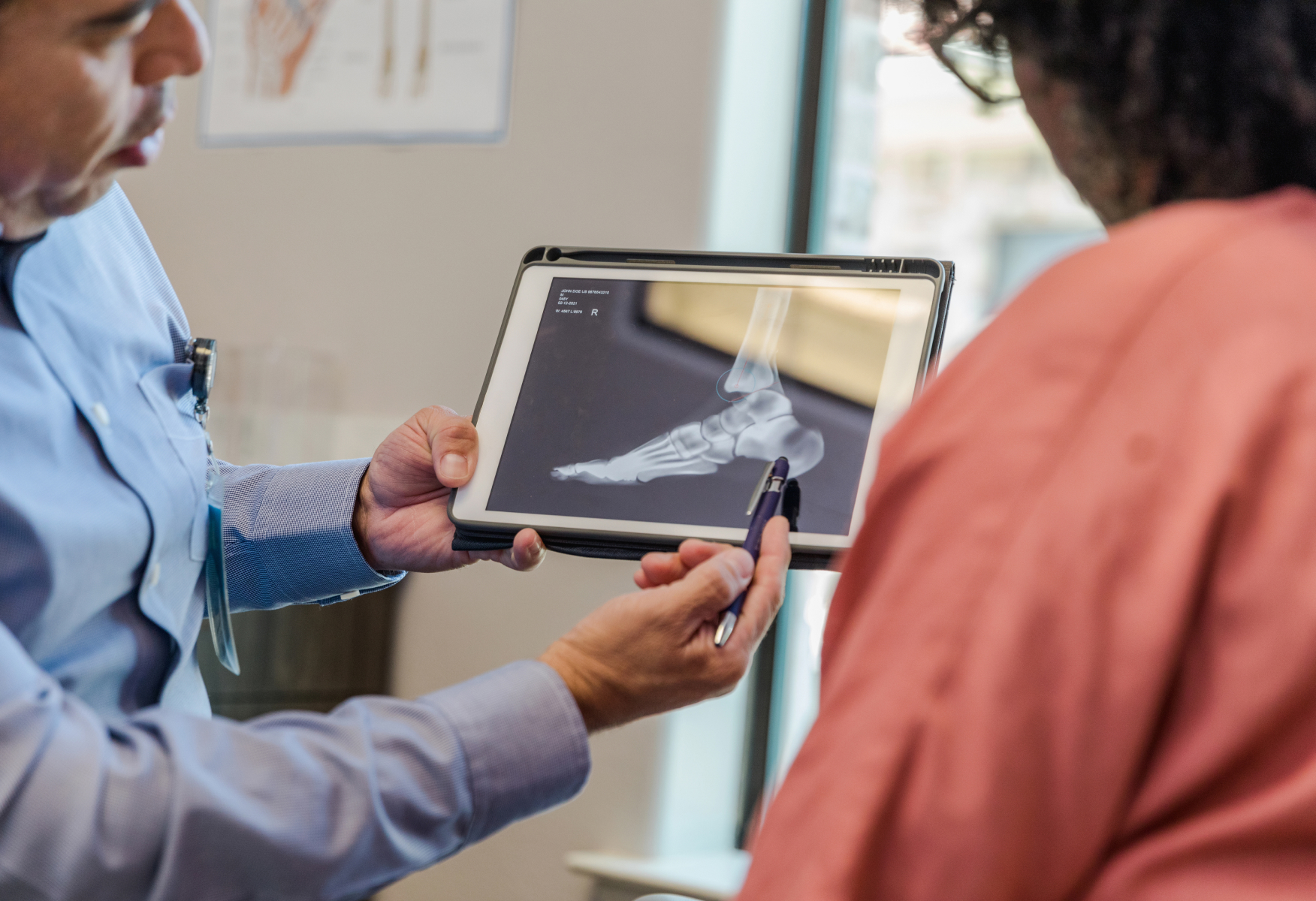 Podiatrist showing foot x-ray to patient